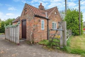 an old brick house with a gate and a fence at 1 Bed in Gainsborough oc-66230 in Heapham