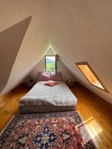 a bedroom with a bed in a attic with a window at Wzgórze Artystów in Głuszyca