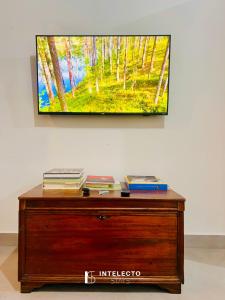 a flat screen tv sitting on top of a wooden dresser at Casa Central Px Matriz c/ Churrasqueira, 2 Suítes in Poços de Caldas