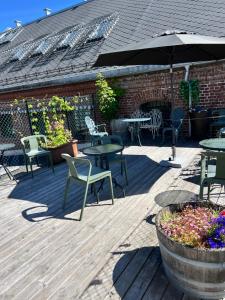a patio with tables and chairs and an umbrella at Fengselshotellet AS in Arendal