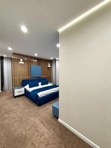 a bedroom with two beds and a wall at Hotel Alto in Karakol