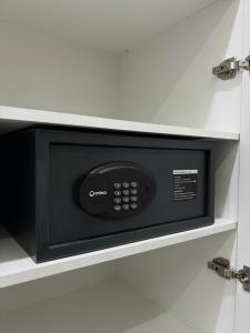 a black microwave oven in a white cabinet at Hotel Alto in Karakol +17 photos