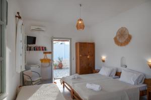 a white room with two beds and a kitchen at Marietta Studios Patmos in Skala