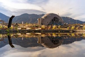 a building with its reflection in a body of water at Glamping Astrapia - Cafayate in Cafayate +8 photos