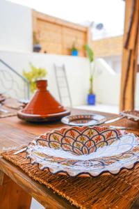 a wooden table with a plate on top of it at Ocean Breeze Guest House in Tamraght Ouzdar +169 photos