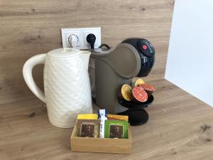 a coffee maker next to a cup and a box at Apartamenty przy Starym Basenie in Sobótka