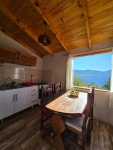 a kitchen with a wooden table and a large window at Cabaña de Mia in Villa Traful