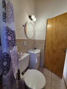 a bathroom with a toilet and a sink and a mirror at Cabaña de Mia in Villa Traful