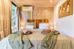a bedroom with a large bed with two pillows on it at Le Secret Tropical - Parenthèse jacuzzi in Sainte-Marie