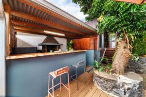 a patio with a bar with chairs and a tree at Le Secret Tropical - Parenthèse jacuzzi in Sainte-Marie