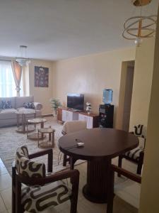 a living room with a table and chairs at Liaden 2 Bedroom Apartment in Nairobi