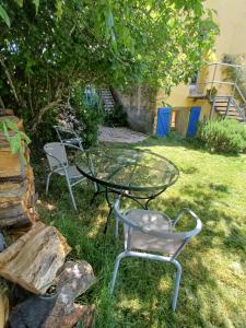 a glass table and two chairs in a yard at Loft 5 personnes dans ferme provençale in Ongles +8 photos