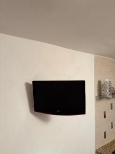 a flat screen tv mounted on a white wall at SnowWhite Home in Porto Ercole