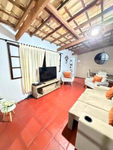 a living room with a tv and a couch at Sítio Sombra da Figueira in Paty do Alferes