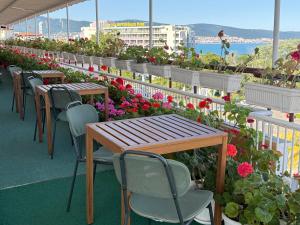 eine Terrasse mit Tischen, Stühlen und Blumen in der Unterkunft Hotel Olymp in Sonnenstrand