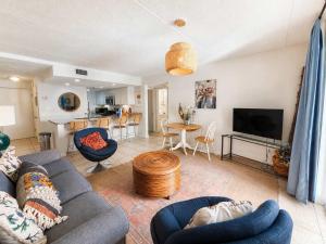 a living room with a couch and a table at Sugar Beach153- 4 pools beachfront in Gulf Shores +23 photos