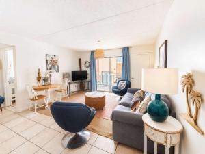 a living room with a couch and a table at Sugar Beach153- 4 pools beachfront in Gulf Shores