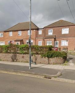 a pole on a sidewalk in front of a brick building at Two Bedroom Flat Bristol in Shirehampton