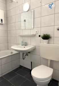 a white bathroom with a toilet and a sink at BEGE APARTMENTS WorkPoint in Dorsten +8 photos