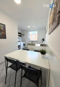 a kitchen and dining room with a white table and chairs at BEGE APARTMENTS WorkPoint in Dorsten