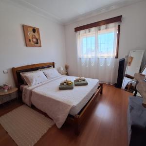a bedroom with a bed with two trays on it at Ana Paula House in Aveiro
