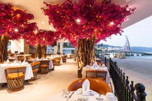 a restaurant with tables and chairs with red flowers at Hotel Casa Dona Susana by Los Arcos in Puerto Vallarta