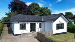 a white house with a black roof at Billund Guest Lodge 2 in Hejnsvig