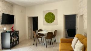 a living room with a table and chairs at Montesanto 60 Suite & Relax Alberobello in Alberobello