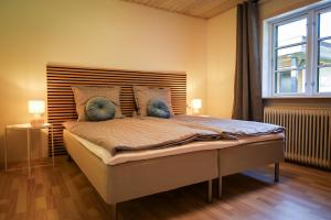 a bedroom with a large bed with a wooden headboard at Billund Guest Lodge 2 in Hejnsvig