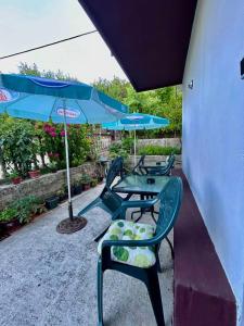 two tables and chairs with umbrellas on a patio at Sobe Mračević in Sutorina