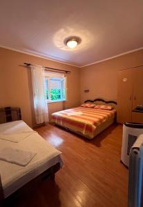 a bedroom with two beds and a window at Sobe Mračević in Sutorina
