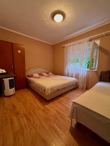a bedroom with two beds and a window at Sobe Mračević in Sutorina