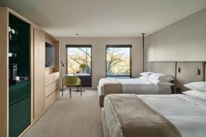 a hotel room with two beds and a television at The Satire, Autograph Collection in Alexandria +82 photos