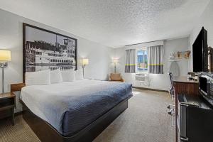 a hotel room with a bed and a television at Super 8 by Wyndham Dubuque in Dubuque