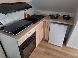 a small kitchen with a stove and a refrigerator at Studio confort in Saint-Omer