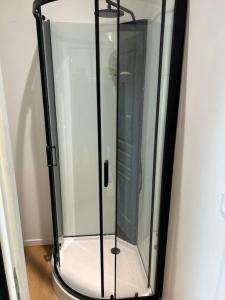 a shower stall with a glass door in a room at Studio confort in Saint-Omer