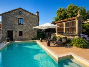 a swimming pool with two chairs and an umbrella at Elemergia in Irijoa