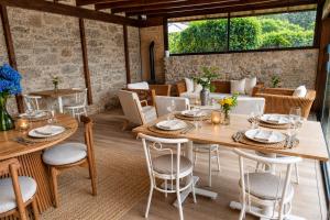 a dining room with tables and chairs and windows at Elemergia in Irijoa
