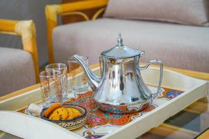 a coffee table with a tea kettle and cookies on it at Ocean Breeze Guest House in Tamraght Ouzdar