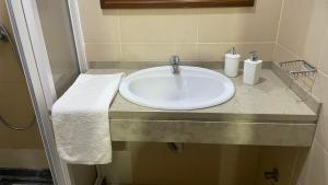 a white sink in a bathroom with a towel at Residencial FSFA in Praia