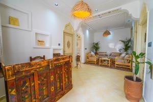 a living room with a wooden cabinet and a couch at Ocean Breeze Guest House in Tamraght Ouzdar