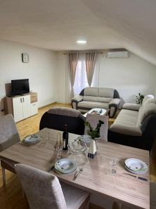 a living room with a table with chairs and a couch at Airport Studio apartman ravna gora in Mitrovići