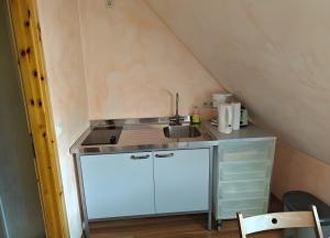 a small kitchen with a sink in a attic at Fewo Backboard in Röbel