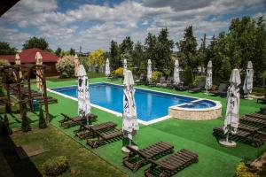 a swimming pool with lawn chairs and umbrellas at Hotel Mondial - Baia in Baia