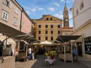 a market in a city with a clock tower at Jazz Apartments in Piran
