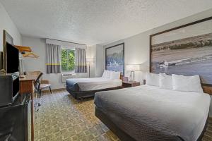 a hotel room with two beds and a flat screen tv at Super 8 by Wyndham Dubuque in Dubuque