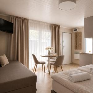a bedroom with a bed and a table with chairs at Szarotka Łeba - nowe domki blisko plaży in Łeba