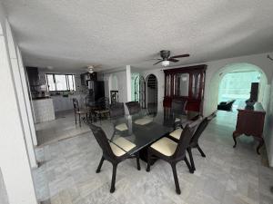 a dining room and living room with a table and chairs at Casa Arabesca in Acapulco