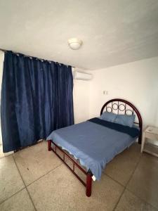 a bedroom with a bed and a blue curtain at Casa Arabesca in Acapulco
