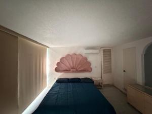 a bedroom with a bed with a large pink headboard at Casa Arabesca in Acapulco